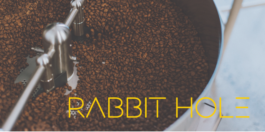 Coffee grinder with coffee beans and 'Rabbit Hole' branding.